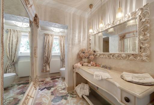 Lidia Bersani / Luxury Interior - Elegant bathroom with beautiful mosaic in flowers on the floor. Furniture in cream color. Silk curtains in the windows   